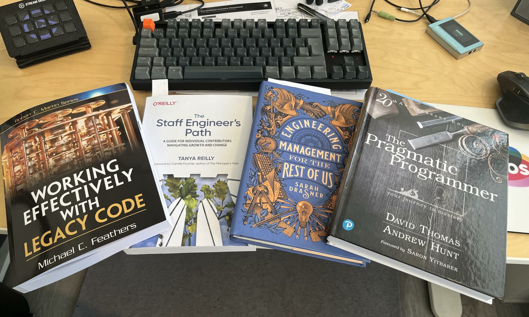Four books like in a desk with a keyboard.

1) Working effectively with legacy code
2) The Staff Engineer’s Path
3) Engineering management for the rest of us
4) The Pragmatic Programmer