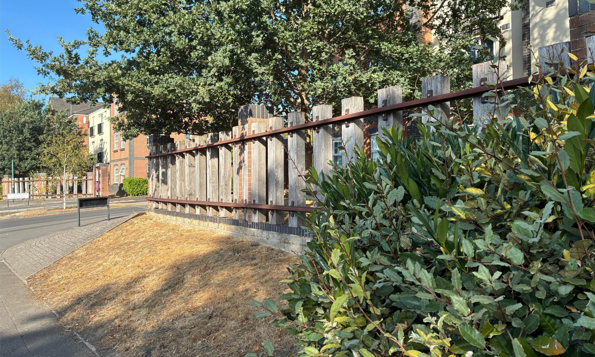 A large fence where the uprights are railway sleepers and the horizontal crossbars are actual railway rails. Like they turned the railway on its side.